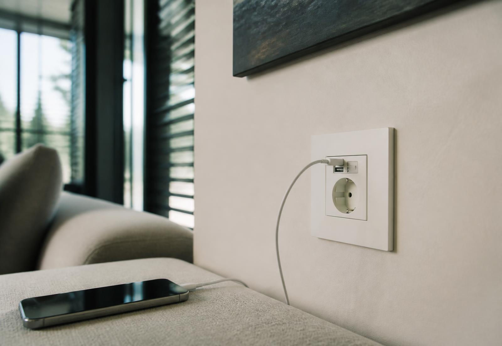 Wit Tysellin stopcontact met ingebouwde USB-C in een moderne woonkamer